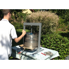 Man using a hydraulic press to juice apples.