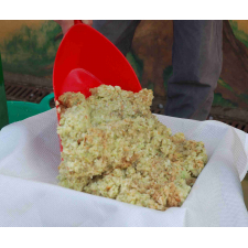 Crushed apple pomace with red scoop.