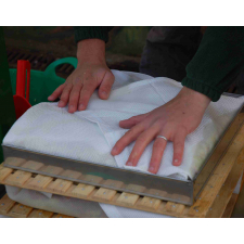 Man making a fruit pomace cheese for pressing.