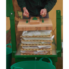 Man fitting pressing block to pomace cheese.