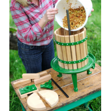 Woman pouring crushed apples into fruit press.