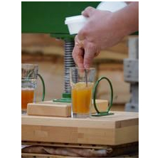A glass of apple juice on top of a press